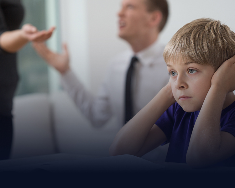 A young boy in distress, holding his head in his hands